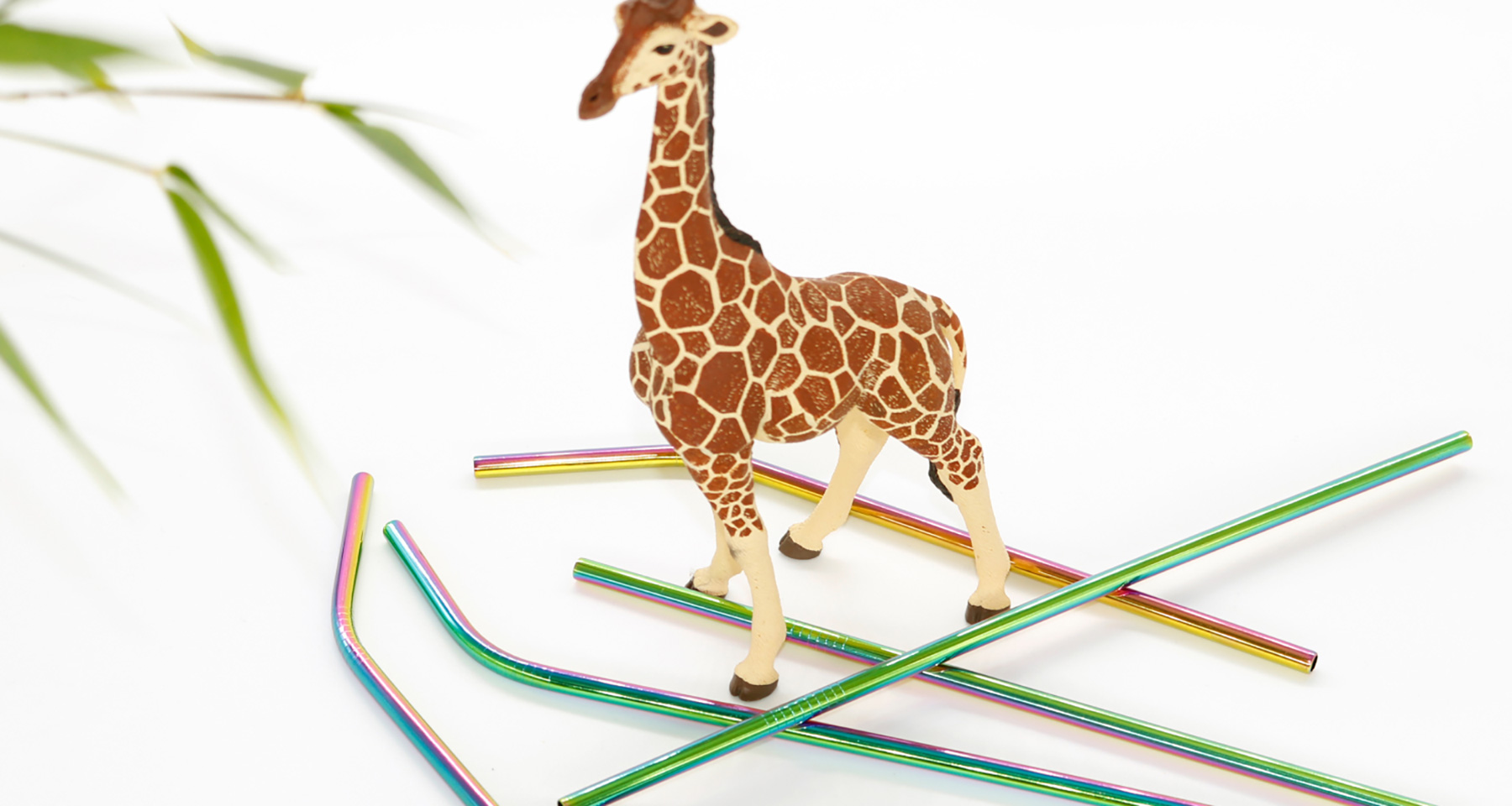 Several straws next to a toy giraffe.