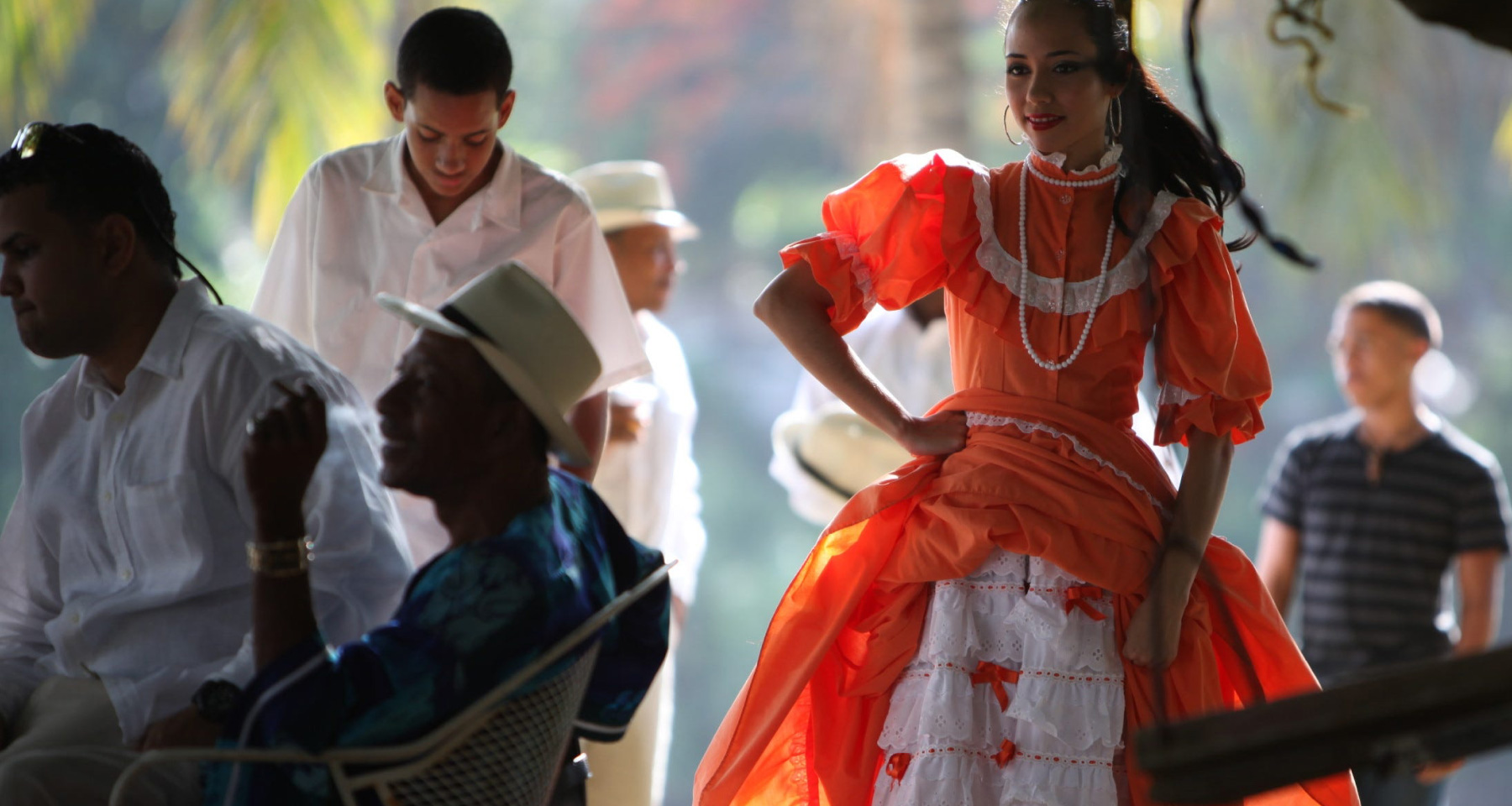 A Hispanic woman in a red dress dancing.