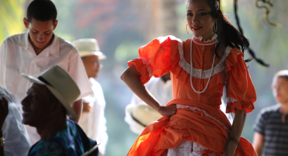 Woman in a red Mexican dress dancing.
